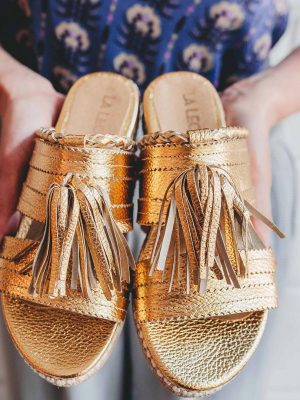 sandalias bajas de cuero dorado con flecos